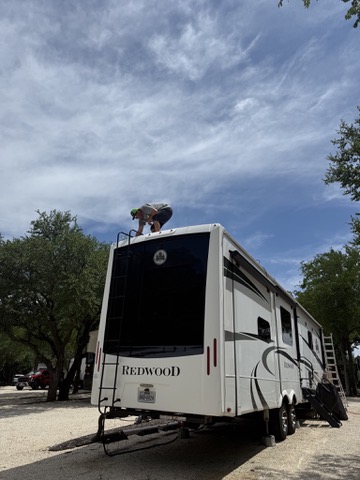 Rich Mahre, founder of ServiceNomad, performing roof repair on a Redwood fifth-wheel RV